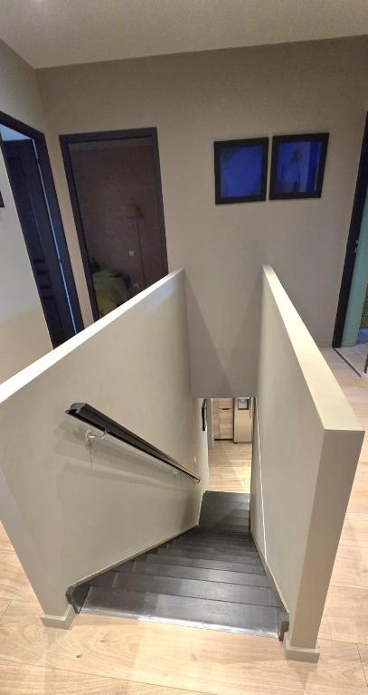 a white staircase in a room with two windows at Characterful house with private pool in Paulhan in Paulhan