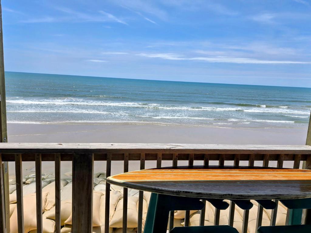 a table on a balcony with a view of the beach at Steps to the Ocean! 219 in North Topsail Beach