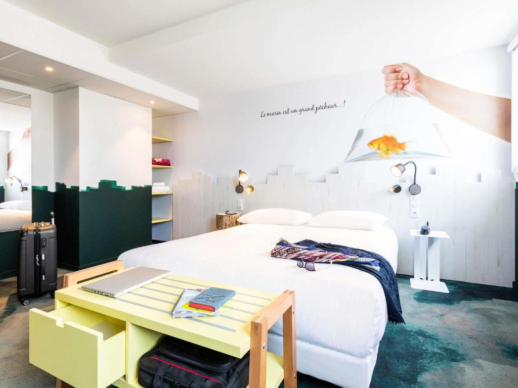 a bedroom with a bed with a desk and a table at ibis Styles Thonon-les-Bains in Thonon-les-Bains