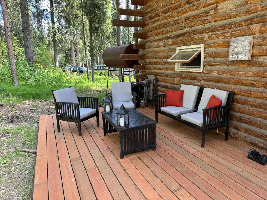 a wooden deck with chairs and a table on a cabin at Little Dry Cabin #3 in Fairbanks