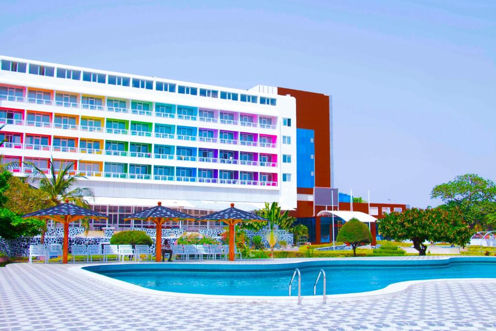 ein Hotel mit einem Schwimmbad vor einem Gebäude in der Unterkunft LEBENE Hotel in Lomé