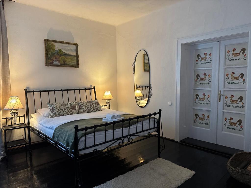 a bedroom with a bed and a mirror on the wall at Casa Alexandra Slătineanu in Bran