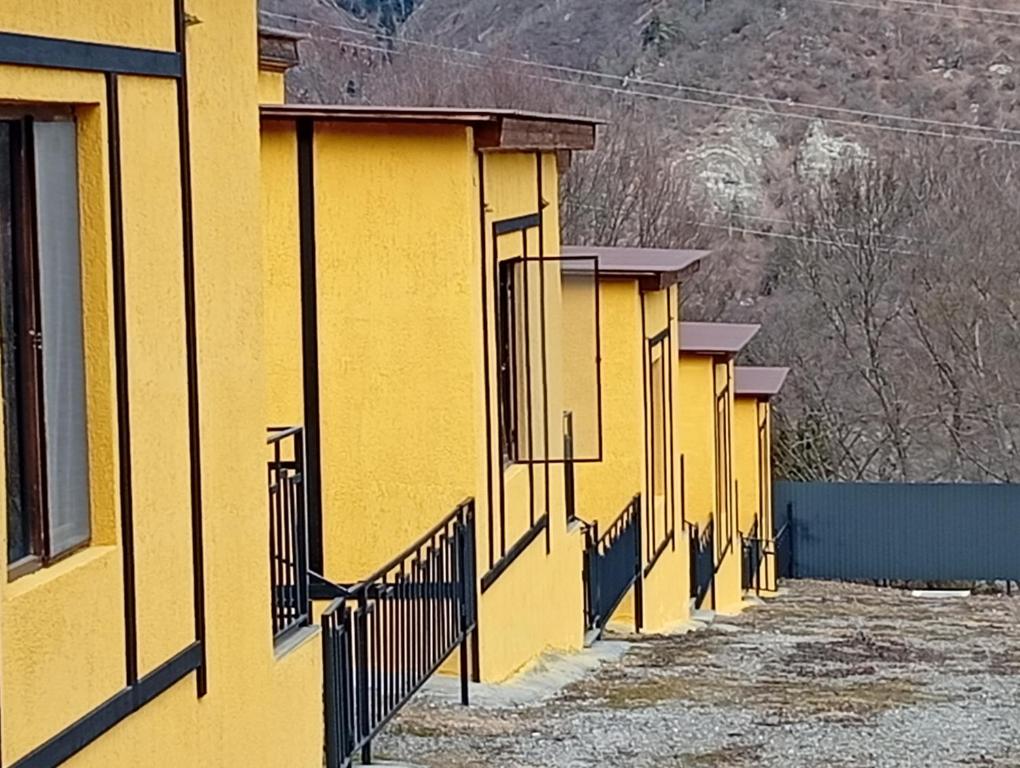 a row of yellow buildings with a fence at Borjomi Paradise in Borjomi
