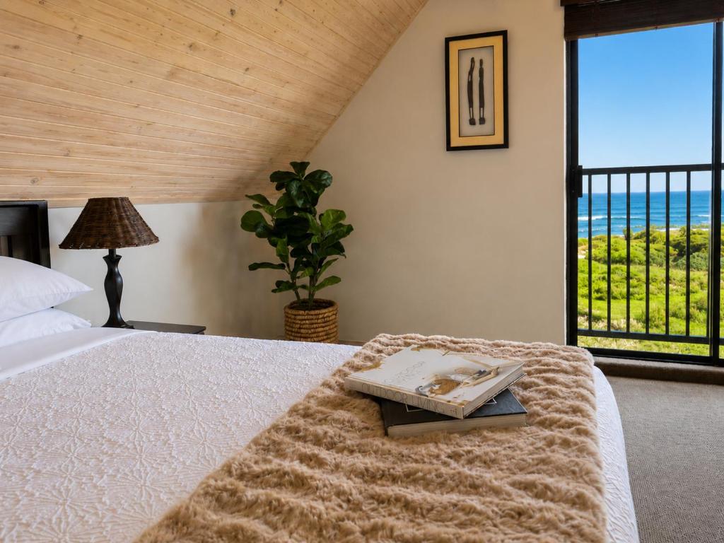 a bedroom with a bed with a view of the ocean at Baviana Beach Lodge - Jacobsbaai - Jacobs Bay in Jacobs Bay