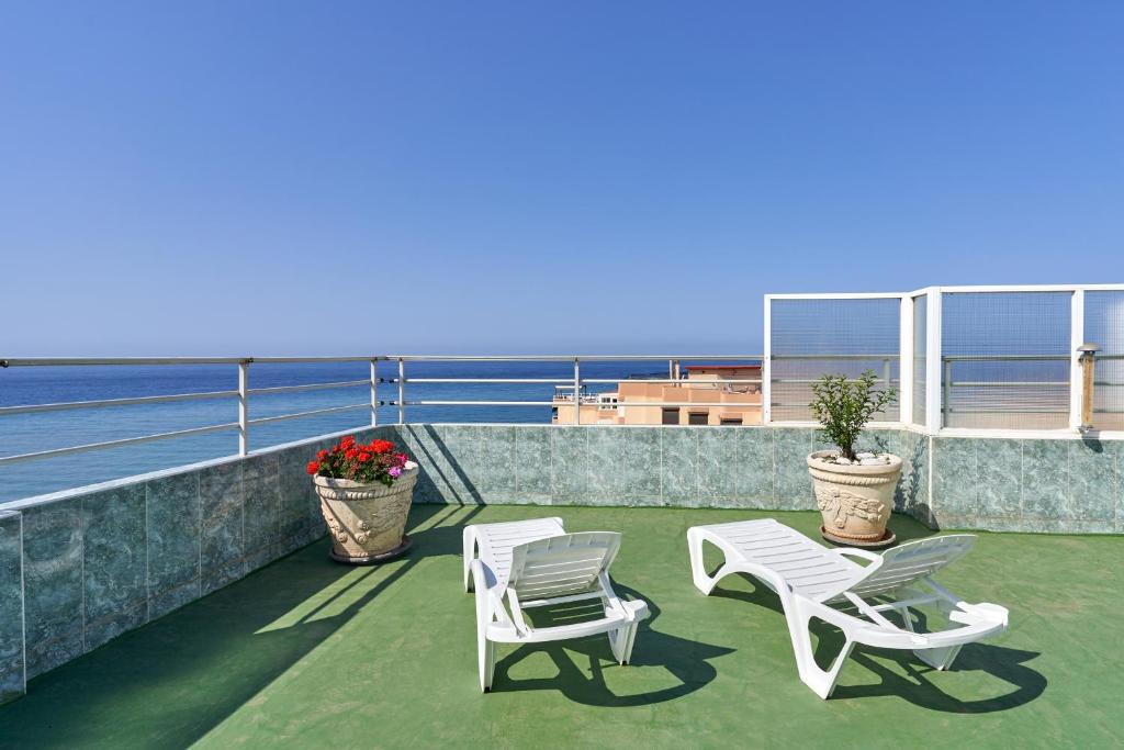 two white chairs and a table and chairs on a balcony at Mirador del Mar in Torrox Costa
