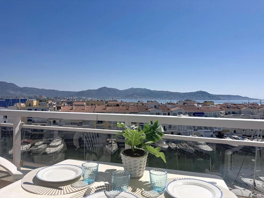 a table with plates on a balcony with a view at Apartment Club Nautic-17 by Interhome in Empuriabrava