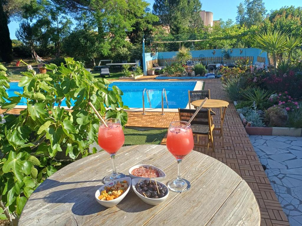 a table with two glasses of juice and bowls of food at Bel Hotel Restaurant la Gentilhommière in Trèbes