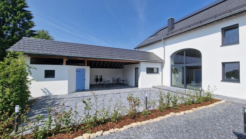 ein weißes Haus mit Garten und Auffahrt in der Unterkunft Haus Chresten in Büllingen