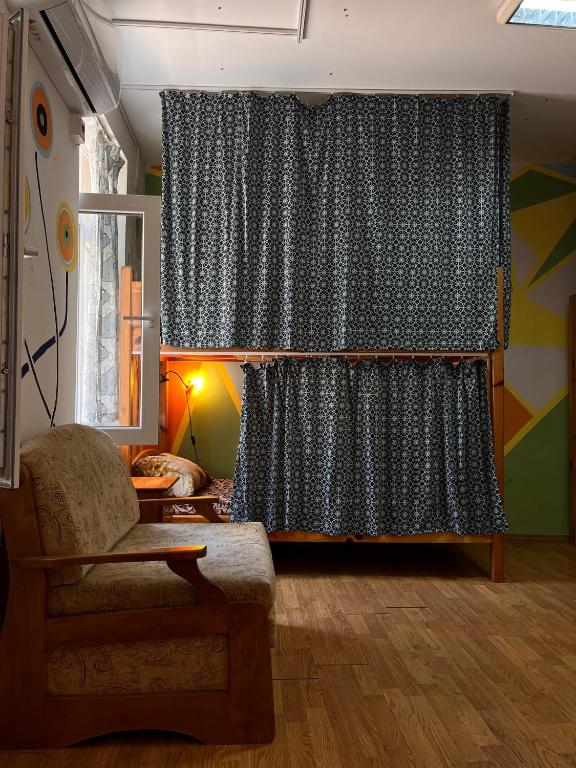 a living room with a curtain and a chair at Just a Hostel in Sozopol