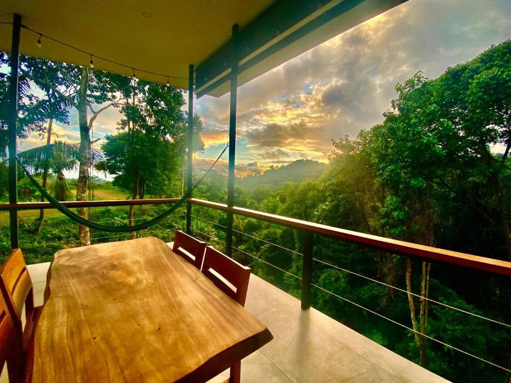 a table and chairs on a balcony with a view at Tierra Encantada in Dominicalito