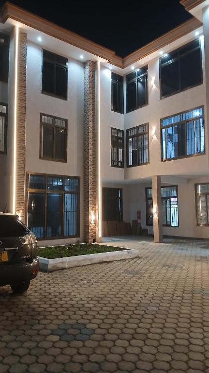 a large building with a car parked in front of it at Cornerstone Hotel Arusha in Arusha