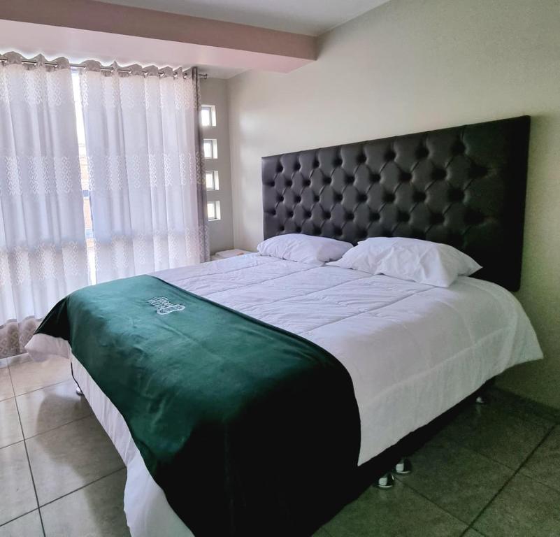 ein Schlafzimmer mit einem großen Bett mit schwarzem Kopfteil in der Unterkunft Hotel Patxy in Concepción
