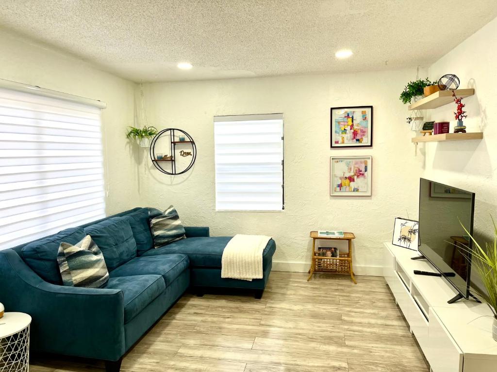 a living room with a blue couch and a television at Sanctuary Retreat Florida HardRock in Hollywood
