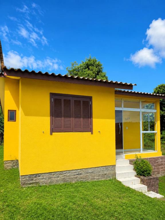 a yellow house with a window at Casa Turista in Cambará