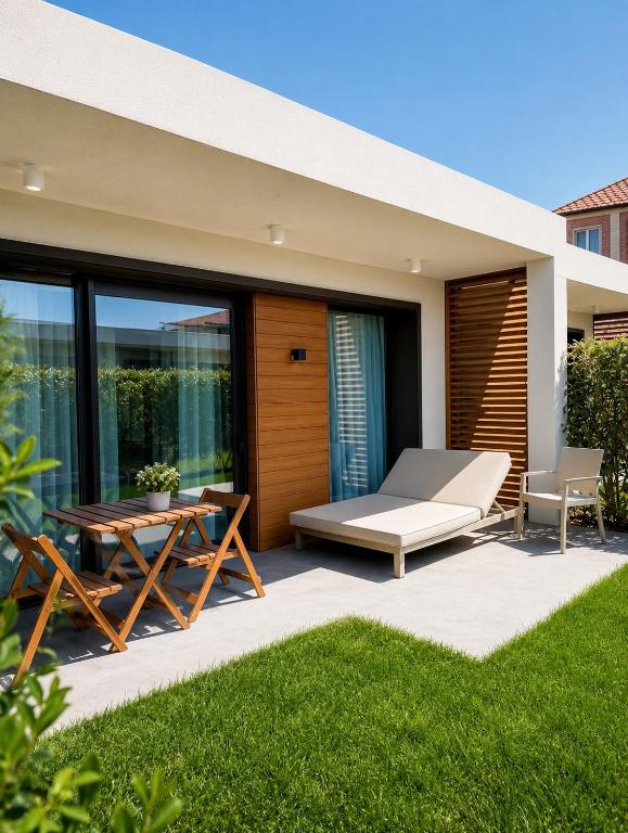 a patio with a table and a bench and a bed at White Villas in Nardaran