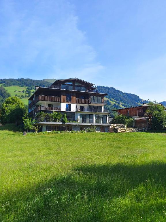 a large house on a hill with a field of grass at Reiterhof in Westendorf