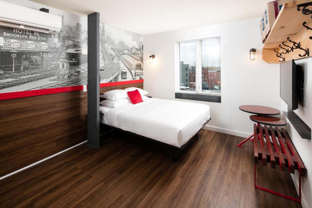 ブルックリンにあるHotel 1080のベッドとテーブルが備わるホテルルームです。