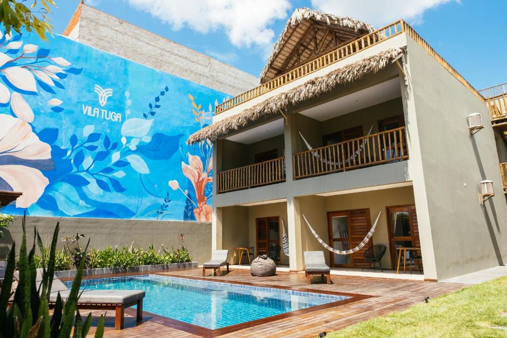 a villa with a swimming pool in front of a building at Vila Tuga in Prea