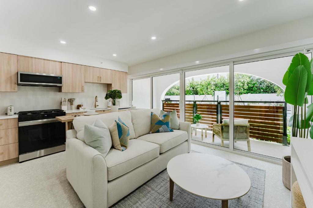 a living room with a couch and a table at The Mizner Pool Suite - Boca Beachside in Boca Raton