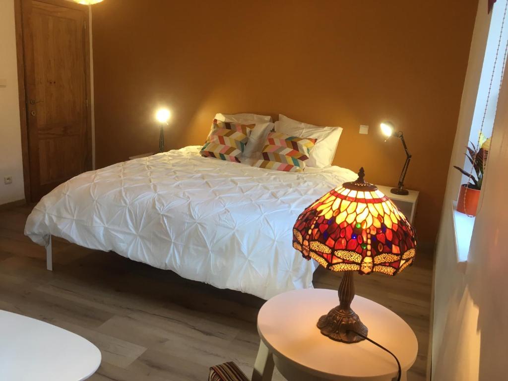 a bedroom with a bed with a lamp on a table at chambre dans les bois in Namur
