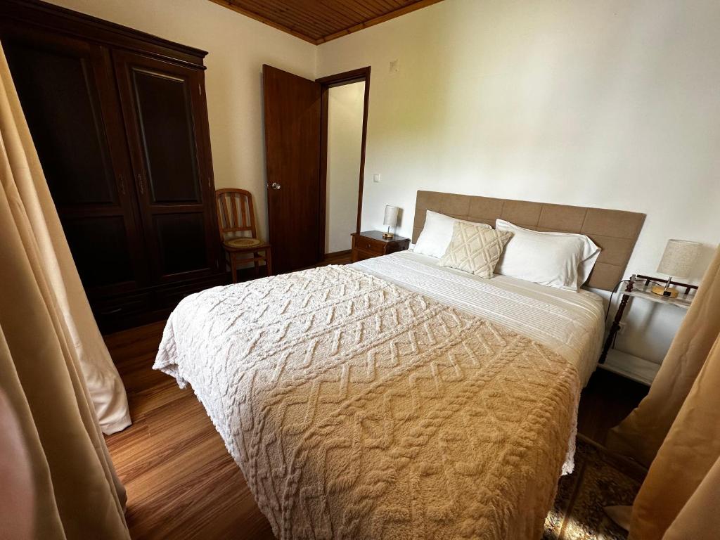 a bedroom with a large bed with white sheets and pillows at Ron House in São Caetano