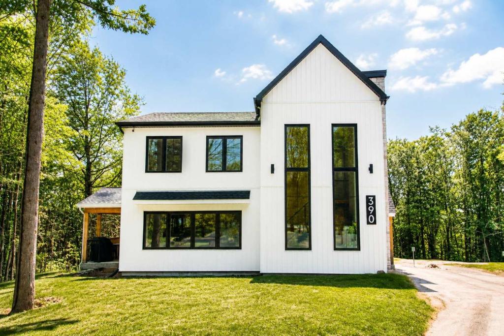 a white house with black windows at Spa & Lili Lake - Le Borea in Chertsey