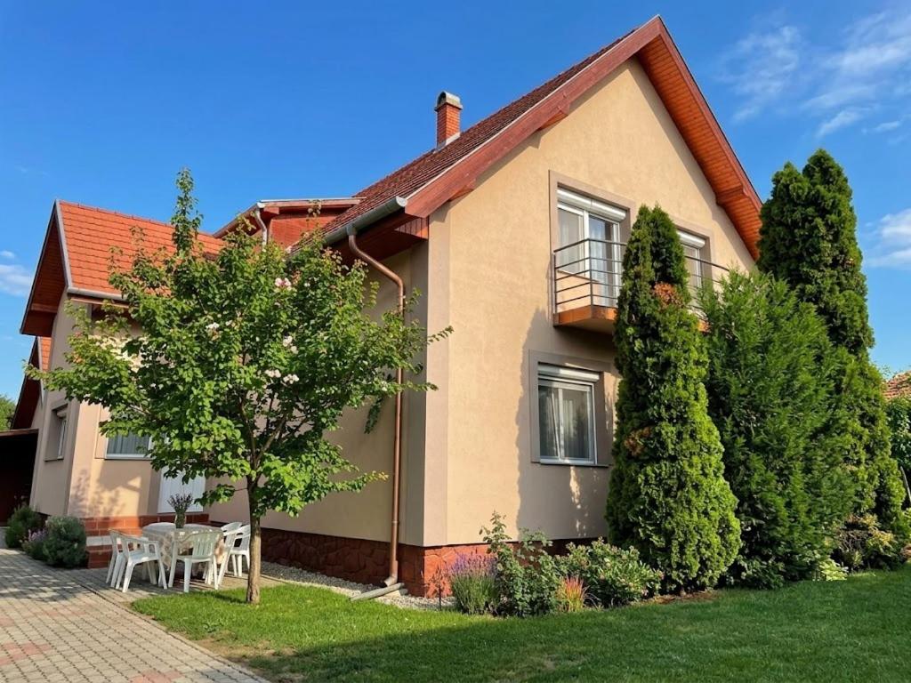 a house with a table and chairs in the yard at Lavender Apartment in Siófok