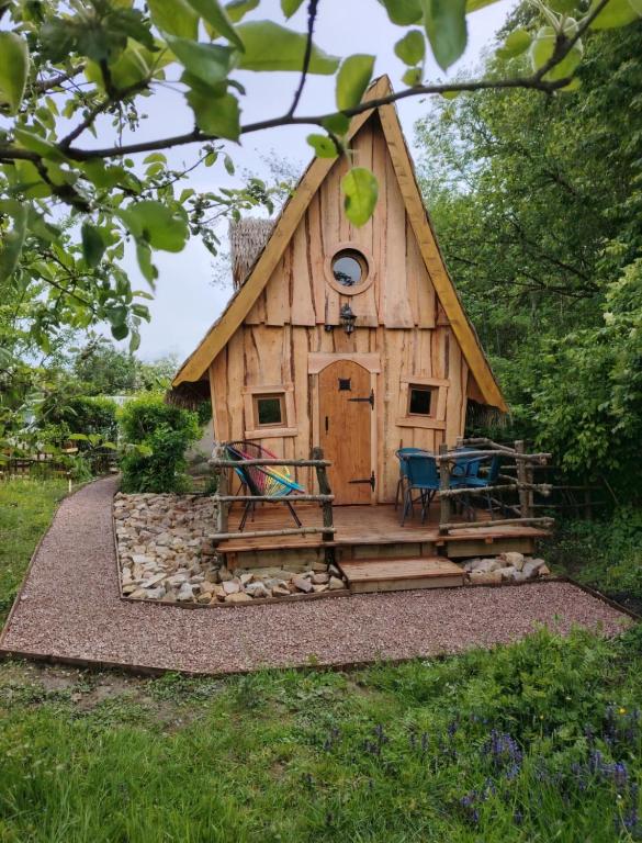 a wooden cabin with a table in front of it at La chaumière ensorcelée in Anor
