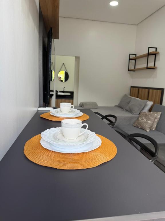 a table with two cups and plates on it at Loft Vip RR in Boa Vista
