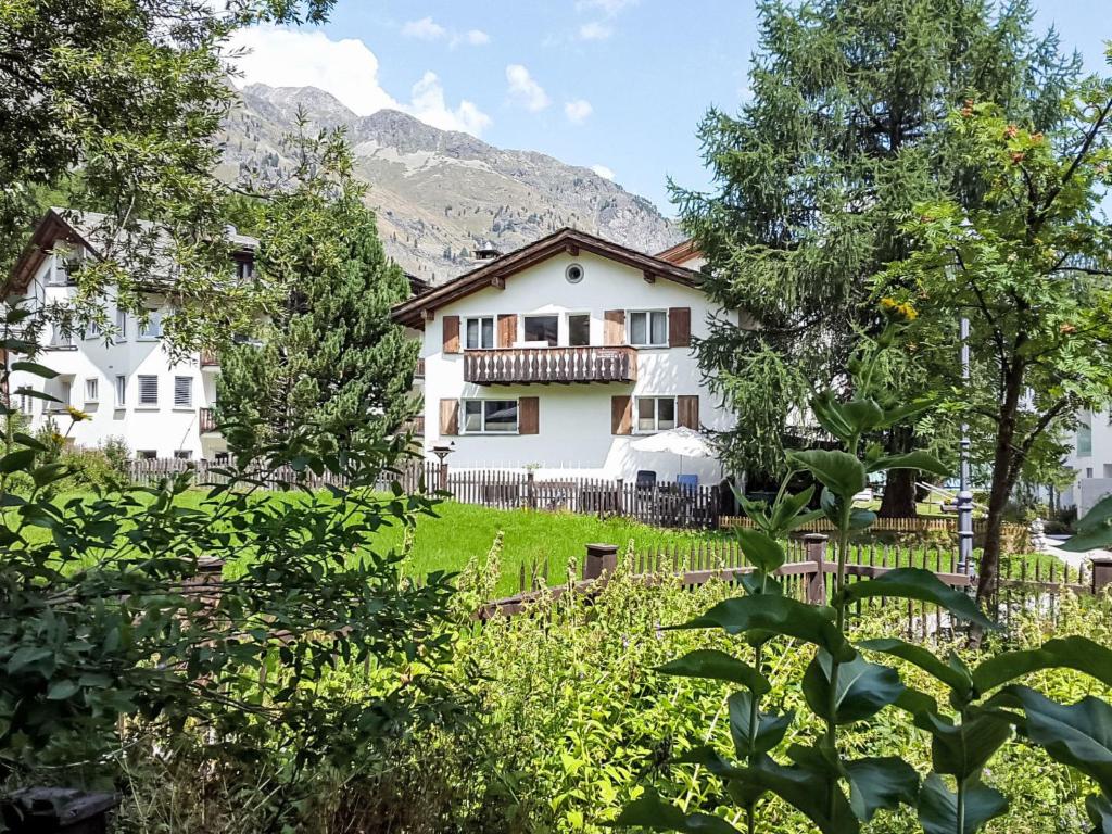 a white house with a fence and trees at Apartment Studio Chesa Marias by Interhome in Sils Maria