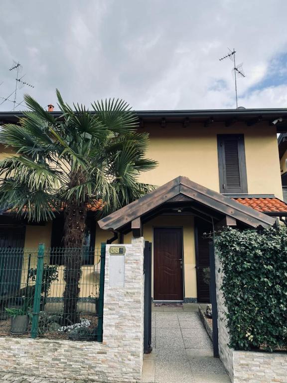 a house with a palm tree in front of it at Il sogno di Eda in Mozzate