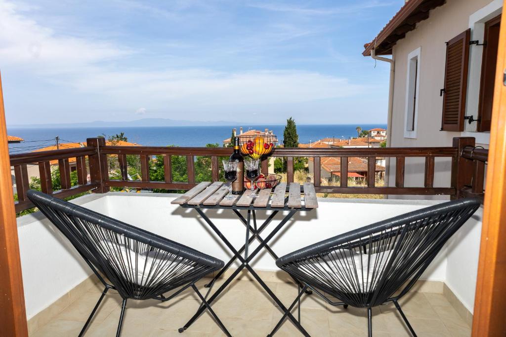 a table and two chairs on a balcony with the ocean at StefanoS Blue Horizon in Afitos