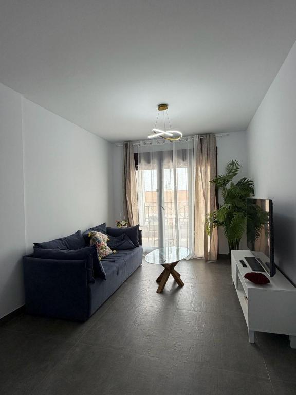 a living room with a blue couch and a table at FoFo Apartamento 78 in Cijuela
