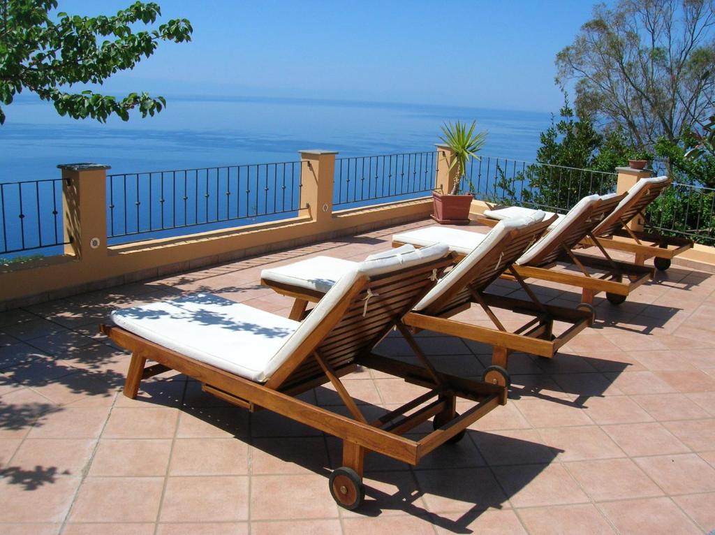 a row of lounge chairs sitting on a patio at Resort Al Belvedere Salina in Leni