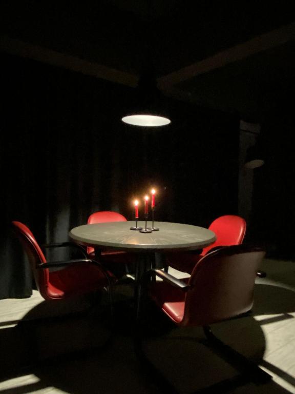 a table with four chairs and candles on it at The secret room in Alba Iulia