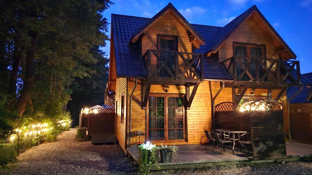 a house with a deck with a table and chairs at Andiland in Karwia