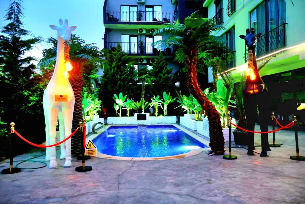 a swimming pool with a giraffe statue next to a building at Grand Bahia Relaxury in Costinesti