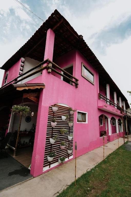 a pink house with a large window at Casa Carol Vans in Peruíbe