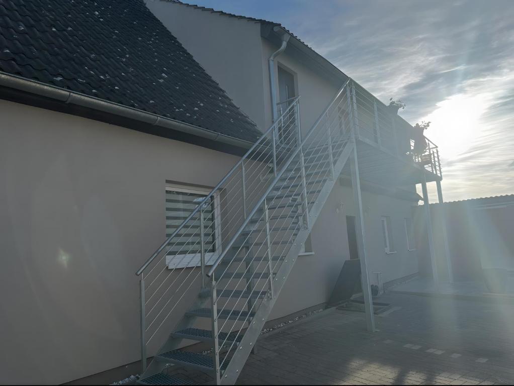 a staircase on the side of a building with the sun in the background at Ostsee-Apartment Wolgast in Wolgast
