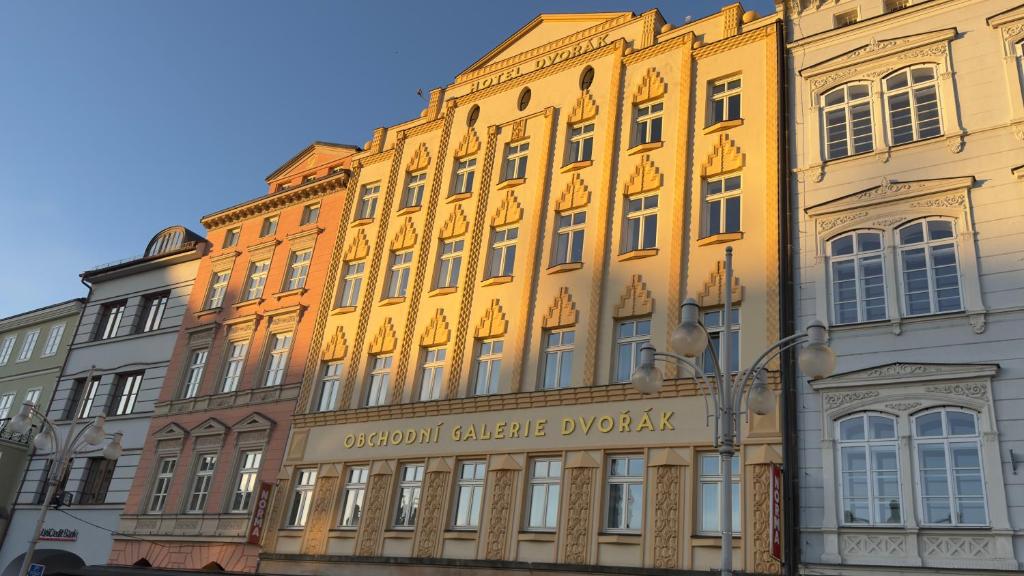 a large yellow building with a sign on it at Hotel Dvorak in České Budějovice