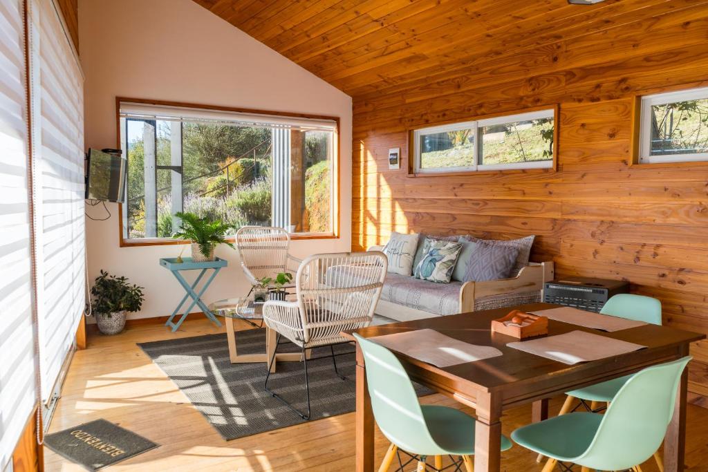 a living room with a table and chairs at Petricor Ecolodge Cab2 in Pucón