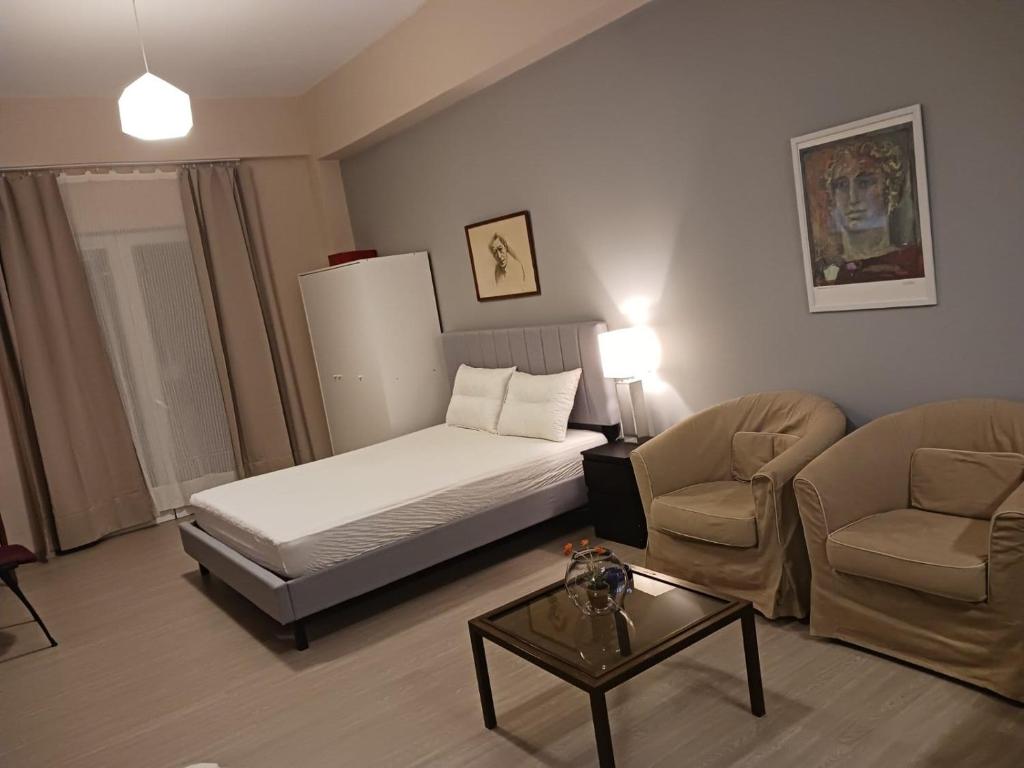 a bedroom with a bed and two chairs and a table at Cozy & modern apartment! in Kiaton