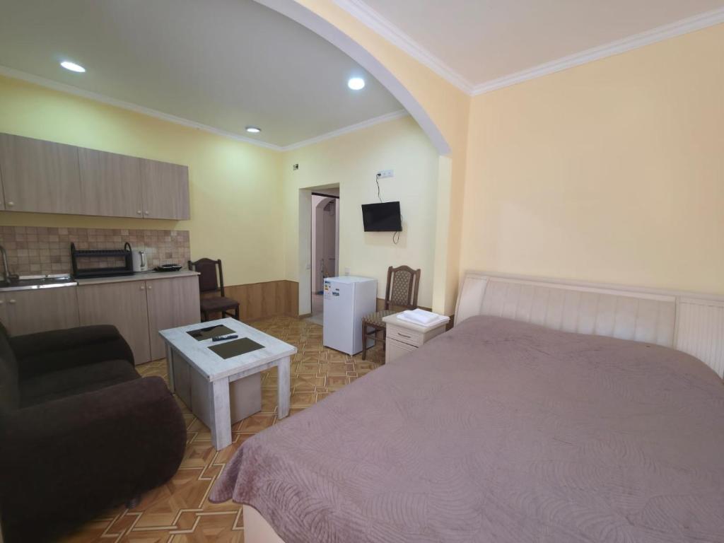 ein Schlafzimmer mit Bett und Sofa und eine Küche in der Unterkunft ОРЕЛ in Yerevan