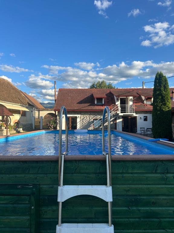 a swimming pool with a chair in front of it at Casa de Piatra in Porumbacu de Sus