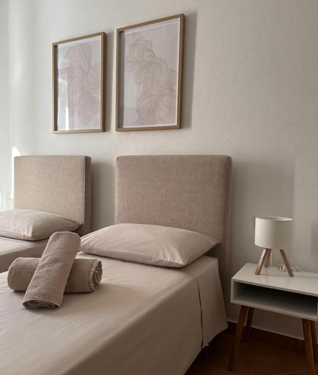 two beds in a bedroom with two pictures on the wall at Cascina Volpi in Montegrino Valtravaglia
