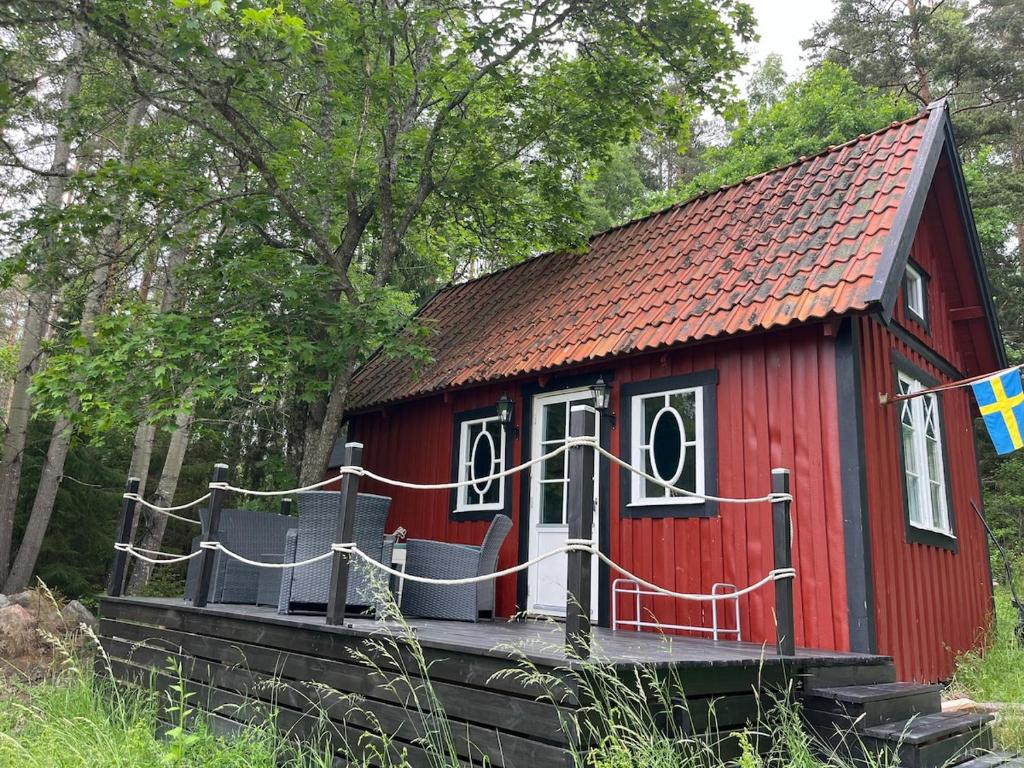 ein kleines rotes Haus mit rotem Dach in der Unterkunft Captain's cabin in Flen