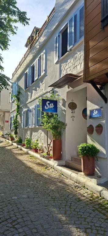 a building with a sign on the side of a street at Bozcaada Su otel in Bozcaada
