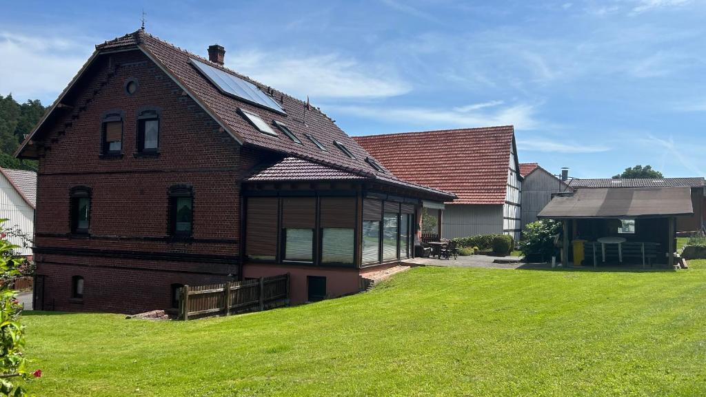 a brick house with a gambrel roof on a lawn at Gerds Gartenwohnung in Ottrau