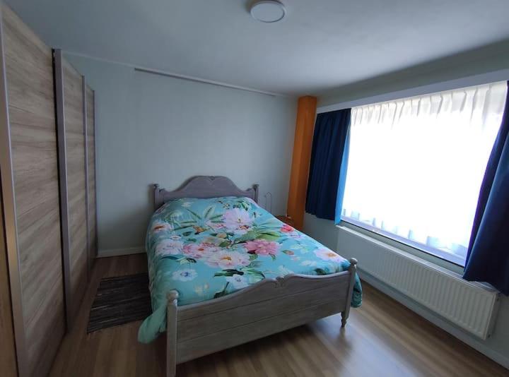 a small bedroom with a bed and a window at Rombaut Restout in Lokeren