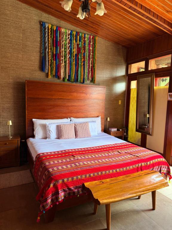 a bedroom with a large bed with a wooden headboard at Casa Micaela in Iquitos
